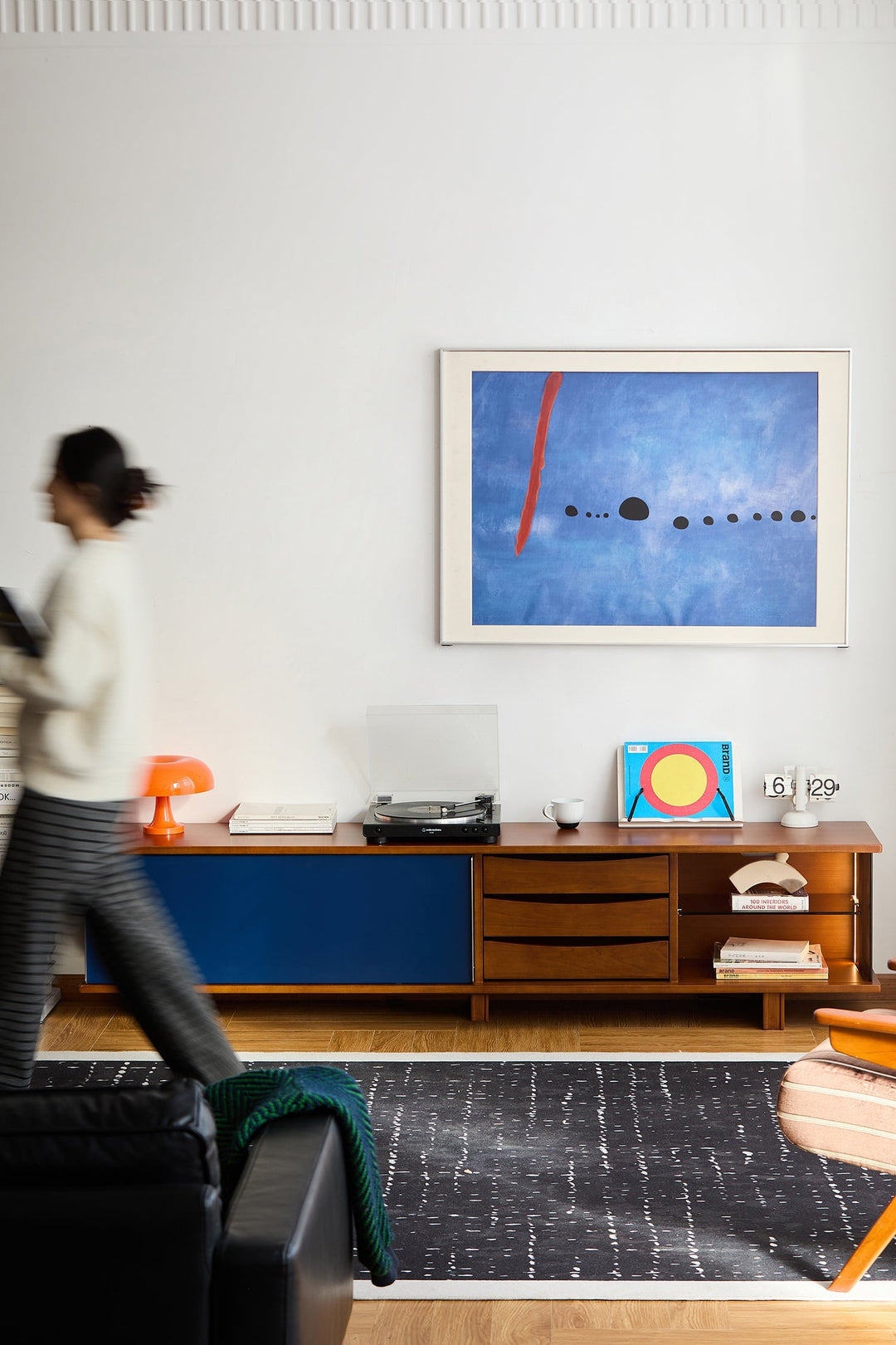 Bauhaus-inspired TV console with blue and wood-tone finish, offering stylish storage and display space for vinyl records, books, and home accessories in a modern living room.