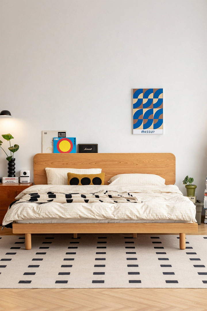 Minimalist oak wood bed frame with rounded headboard, enhancing a modern bedroom with warm tones.