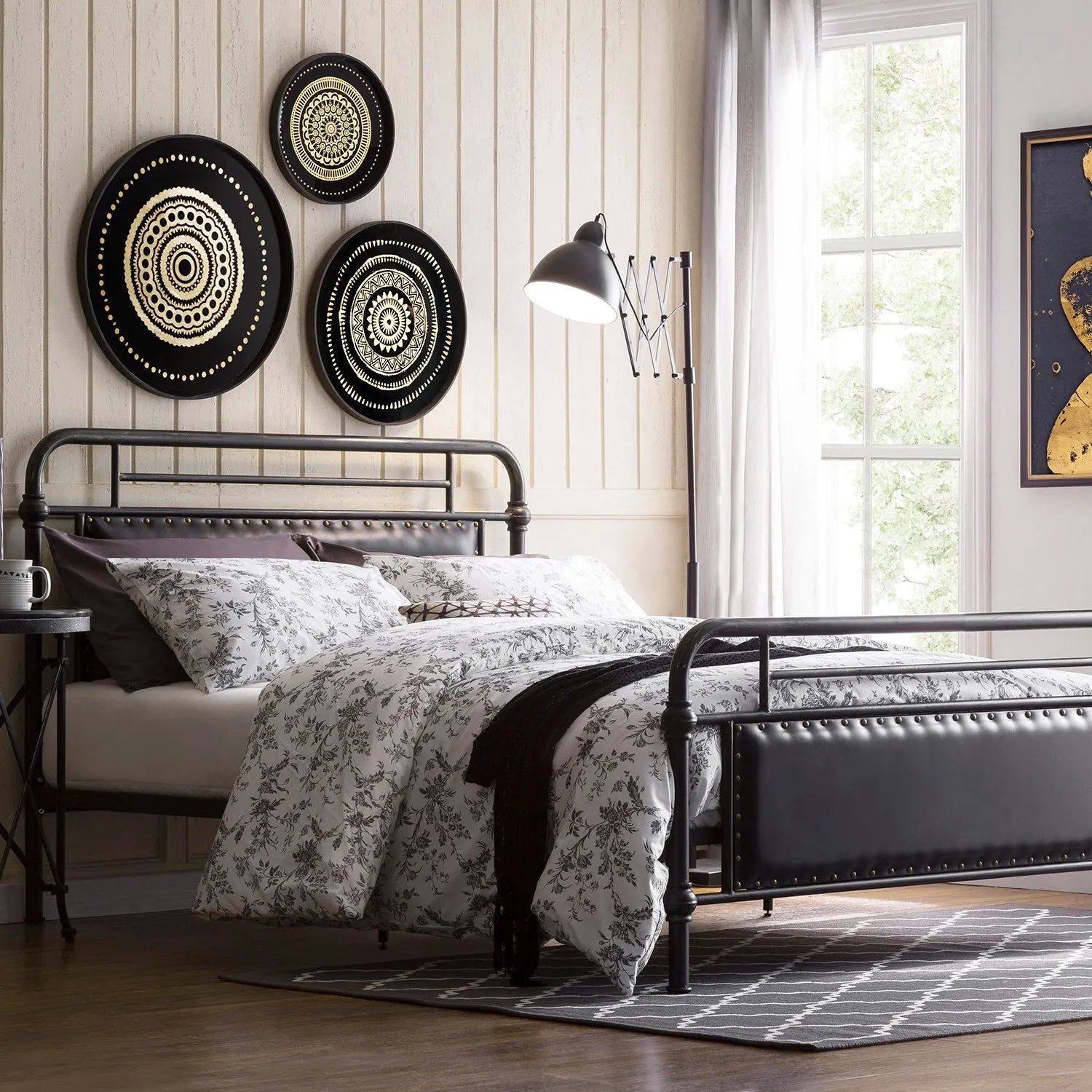 Loft Home metal bed frame with floral bedding, stylish wall decor, and modern lighting in a cozy bedroom with natural light.