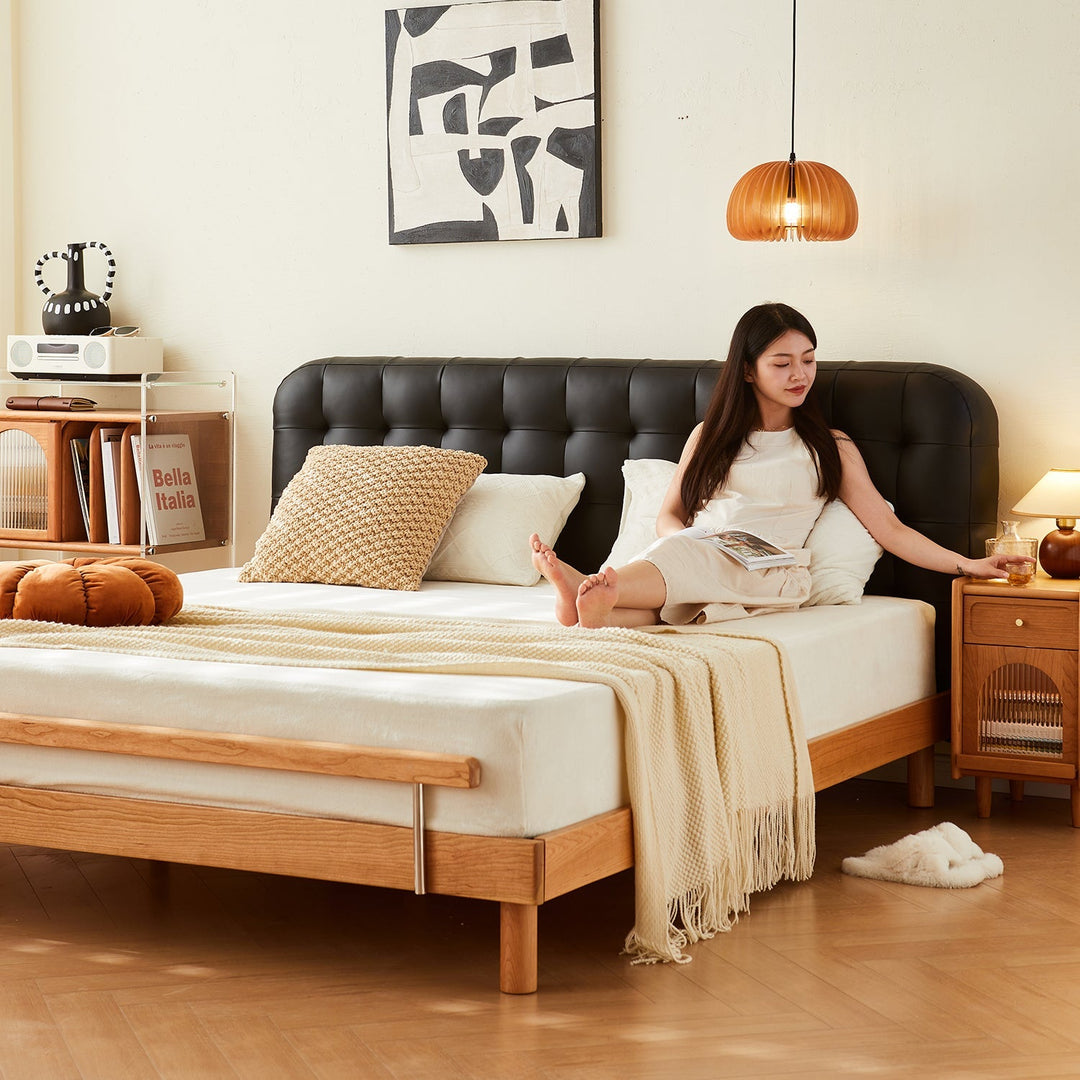 Loft Home top-selling bed frame featuring a sleek black tufted headboard and solid wood base, styled with cozy bedding and a modern bedside table, enhancing contemporary bedroom aesthetics.