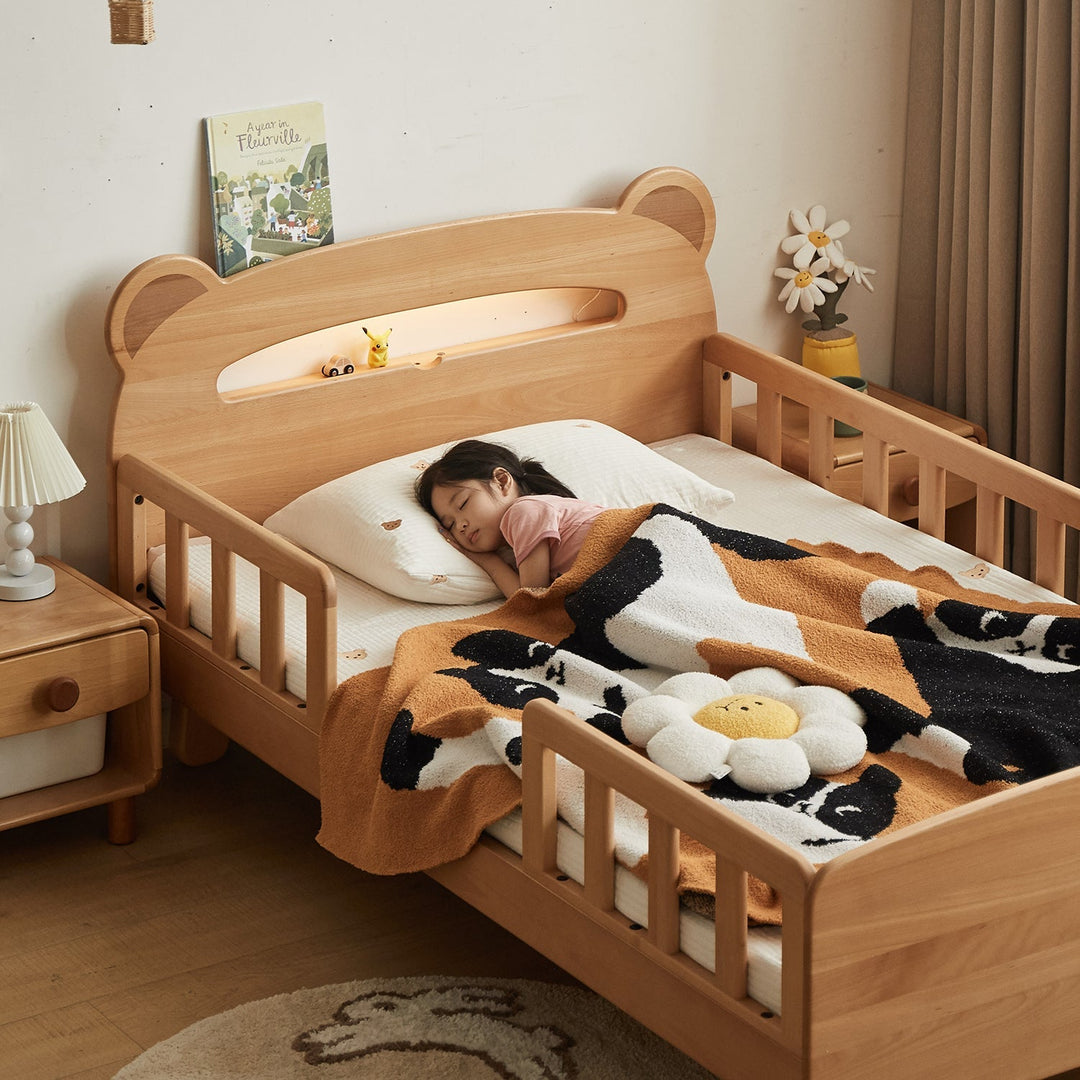 Child sleeping in a wooden bed with animal design, surrounded by a cozy bedroom setting.
