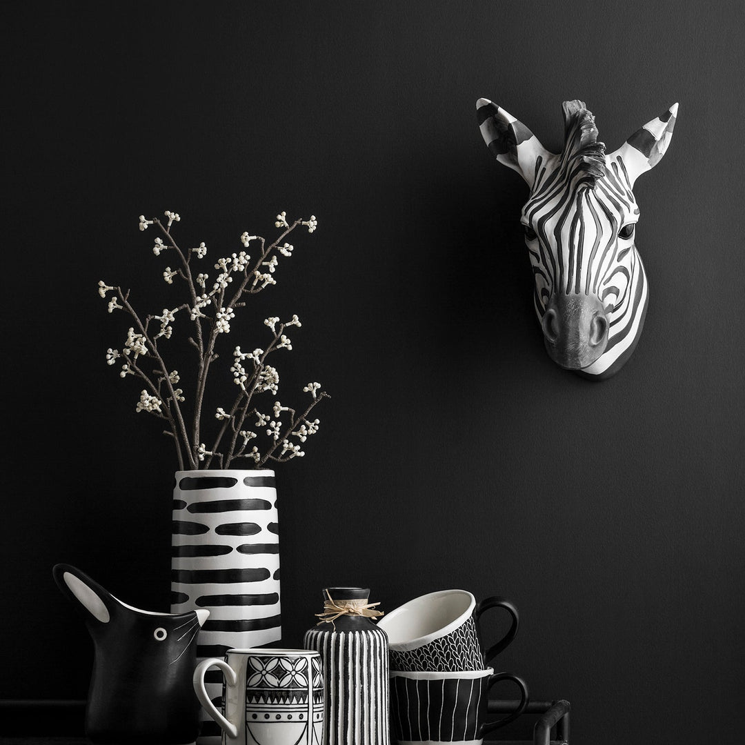 Loft Home black and white zebra-themed decor featuring ceramic vases, mugs, and a zebra wall ornament for a modern, bold statement piece.