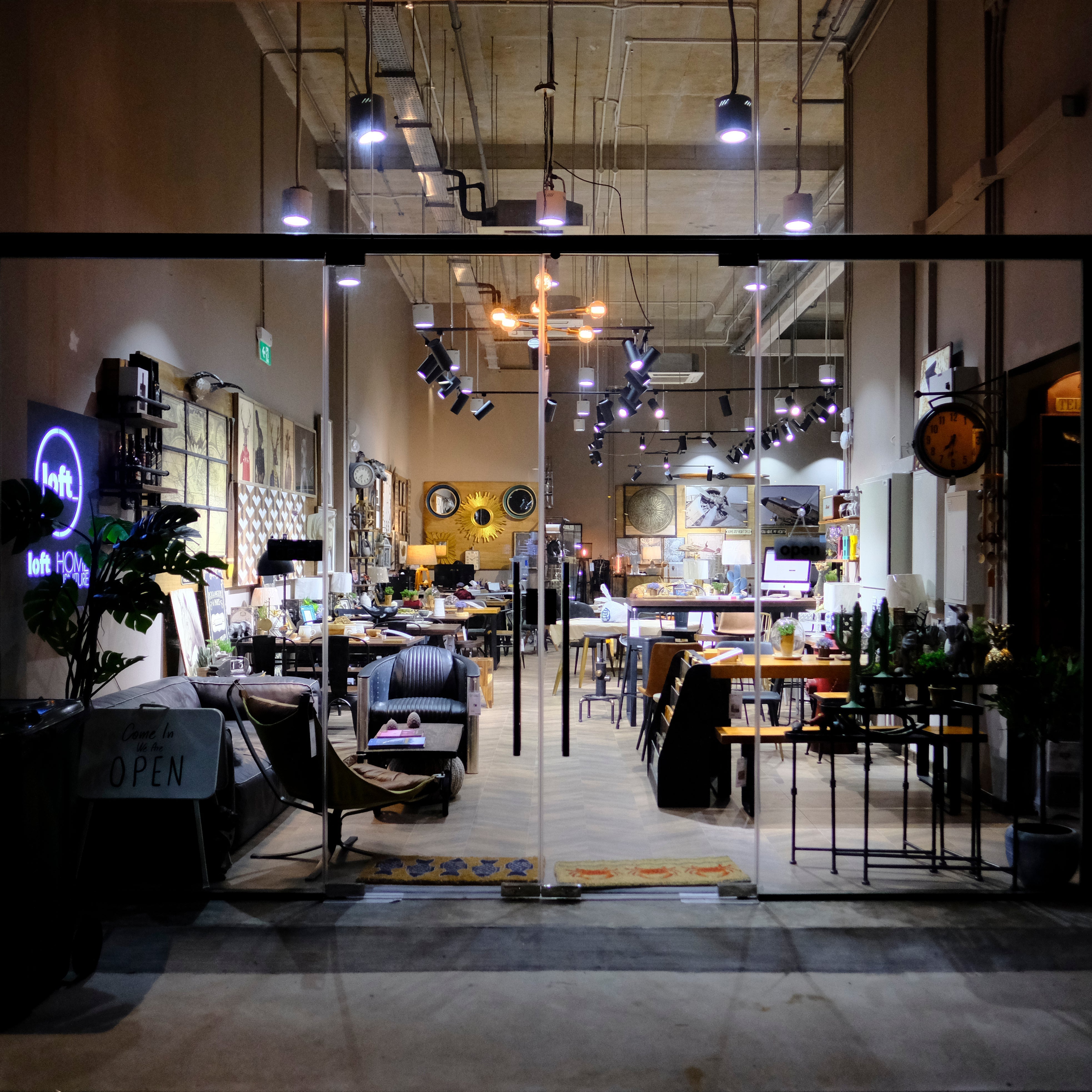 Contemporary black leather 3-seater sofa and modular wood furniture set in Loft Home’s showroom, styled with curated decor and available for display purchase.