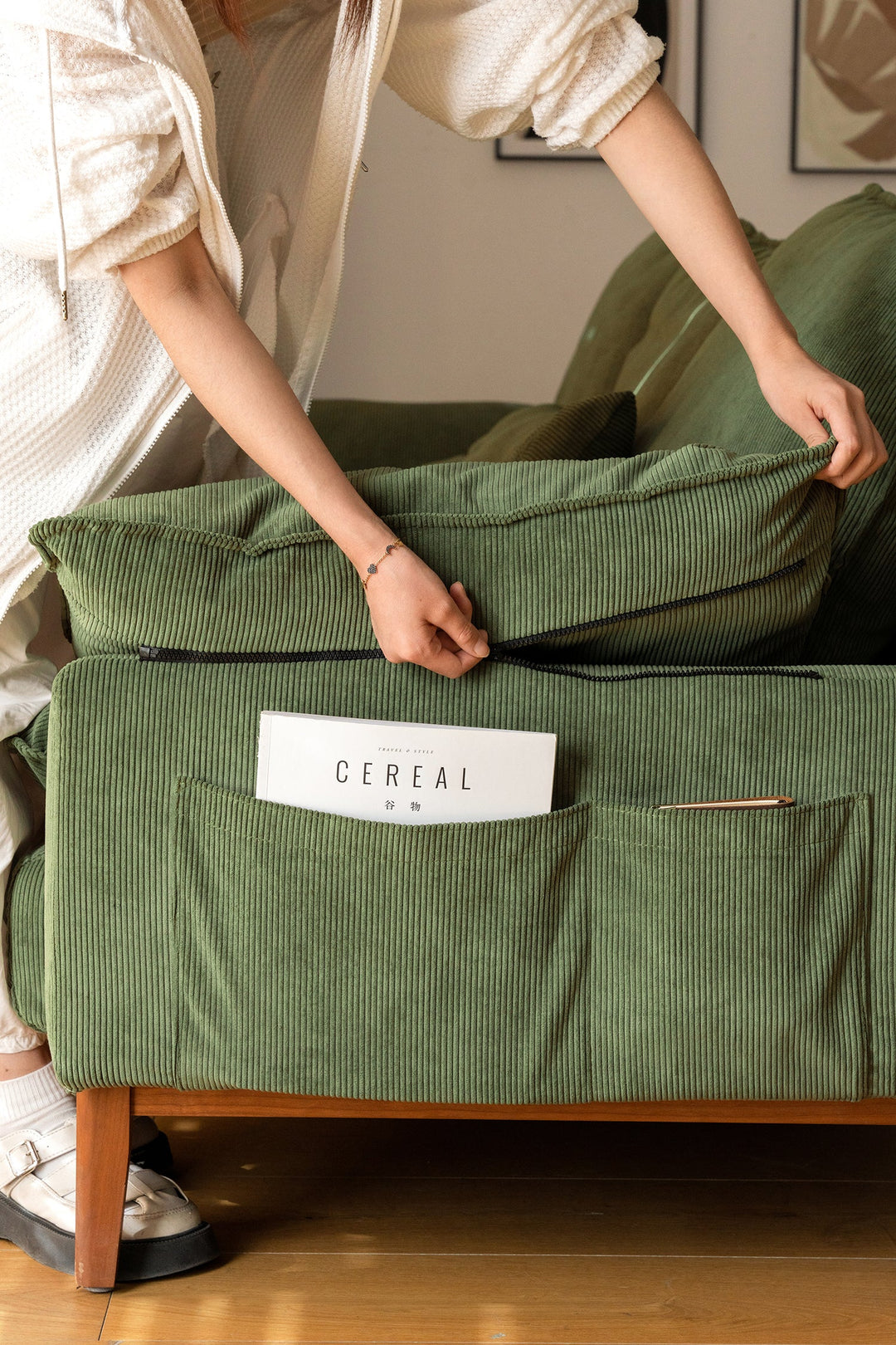 Modern green fabric sofa with side storage pockets and zipper detail, designed for comfortable and organized living rooms in the United States.