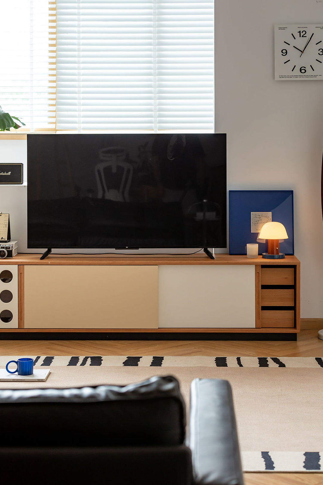 Modern living room with a television on a wooden TV Console, lamp, and decor items. Loft Home TV consoles collection cover picture.