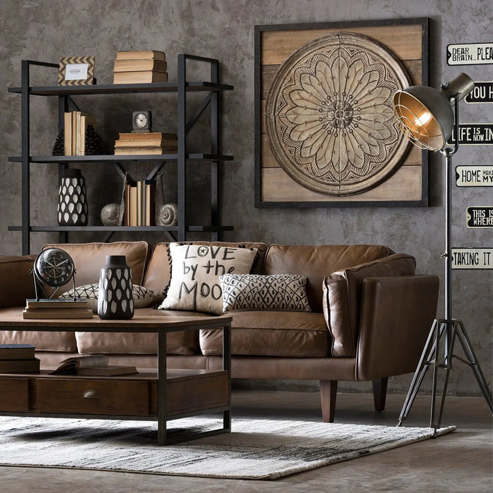 Vintage living room setup with a brown leather sofa, industrial-style coffee table, and decorative shelving, linking to Loft Home's vintage sofas collection.