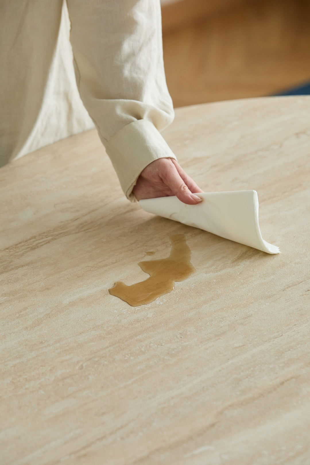 Waterproof table surface being wiped clean, designed for easy-care dining rooms, apartments, and family homes in the US.