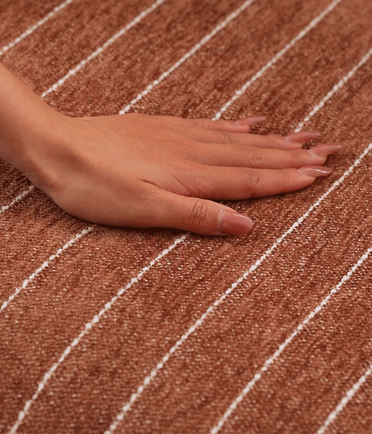 Close-up of brown striped upholstery showing its soft woven texture and white pinstripes.