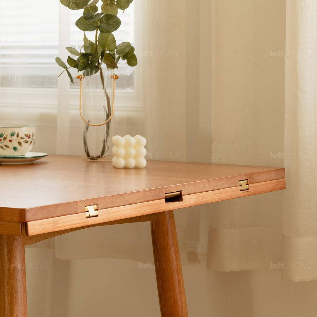 Scandinavian cherry wood extendable round dining table greekn in panoramic view.