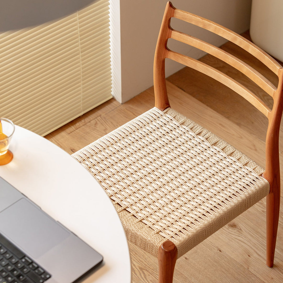 Scandinavian cherry wood woven rope dining chair autumn in close up details.