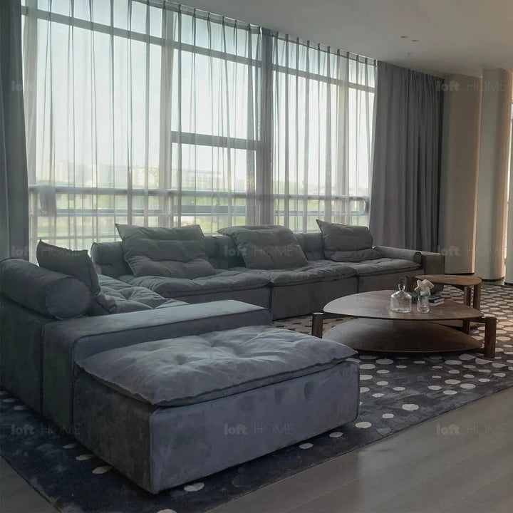 Modern fabric modular 3 seater sofa with ottoman woolen in close up details.