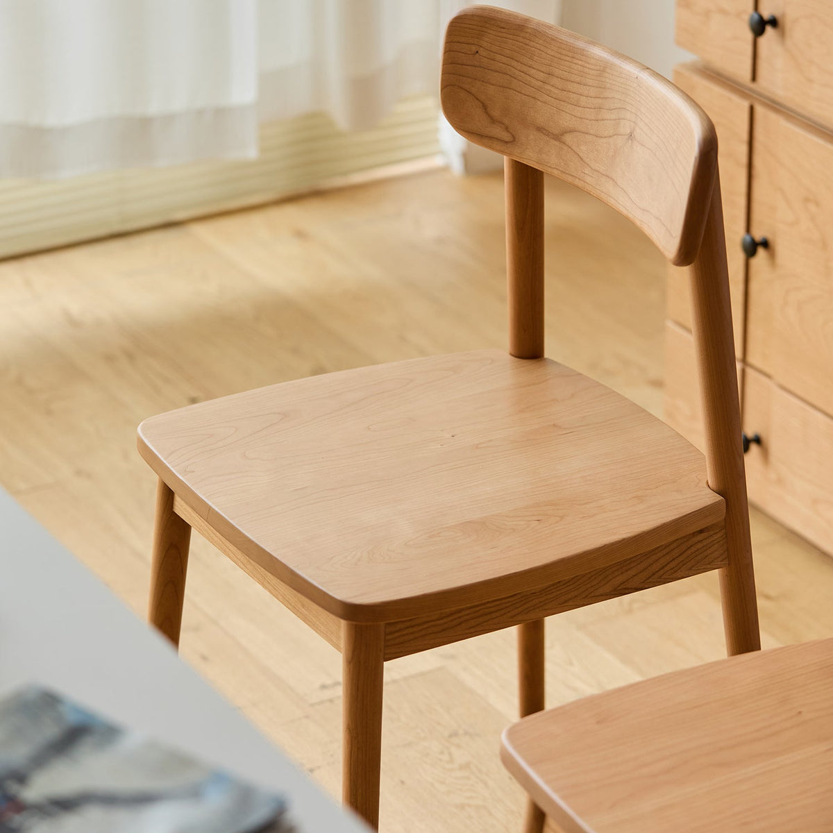 Scandinavian cherry wood dining chair green in panoramic view.