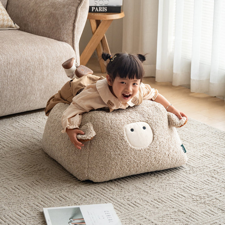 Cream boucle fabric ottoman sheep in still life.