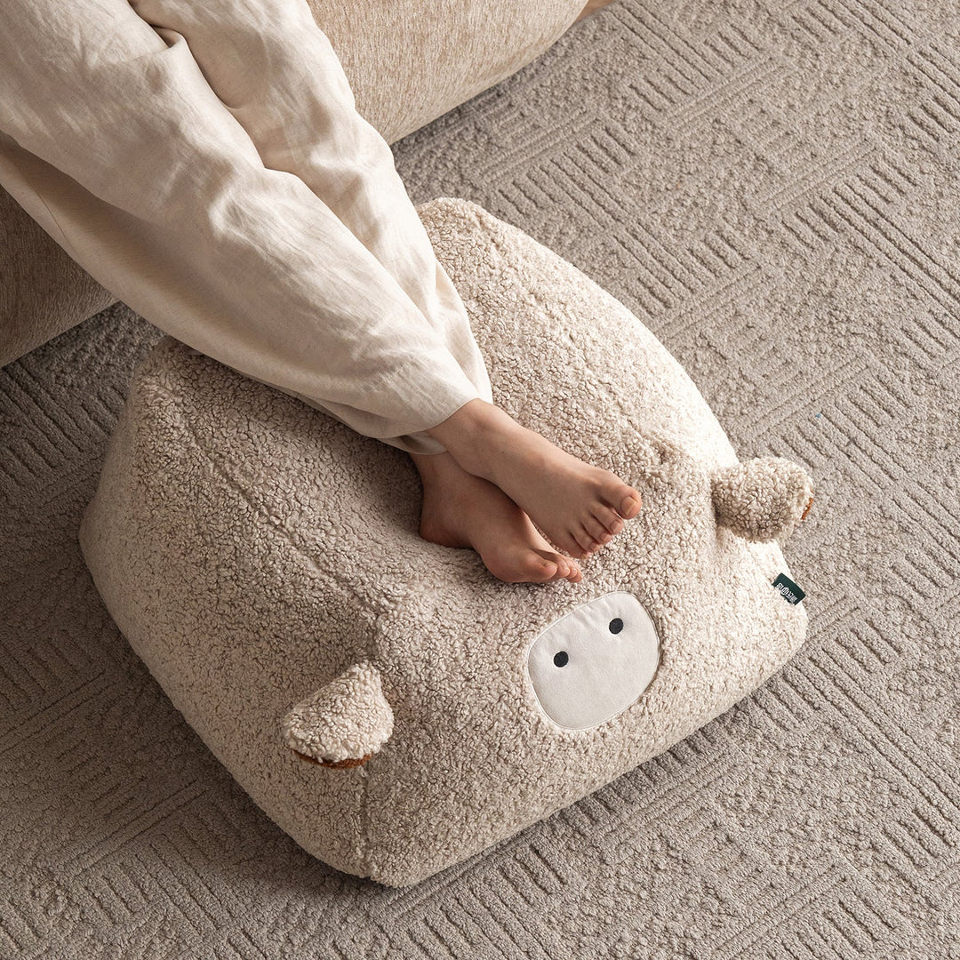 Cream boucle fabric ottoman sheep in details.
