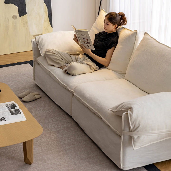 Cream cotton fabric 3 seater sofa folding ear in panoramic view.