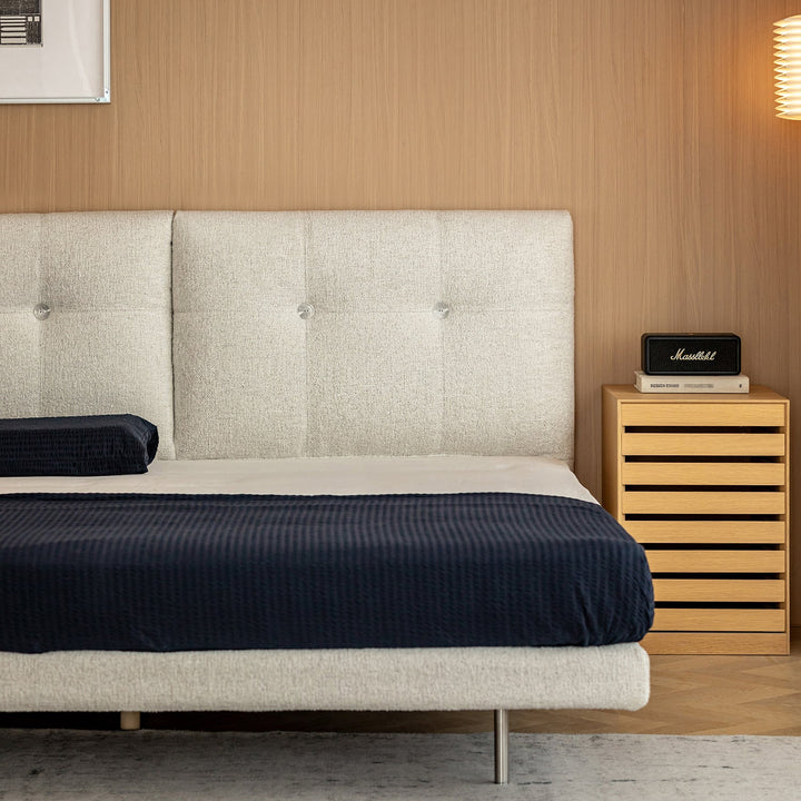 Minimalist boucle fabric bed morn in close up details.