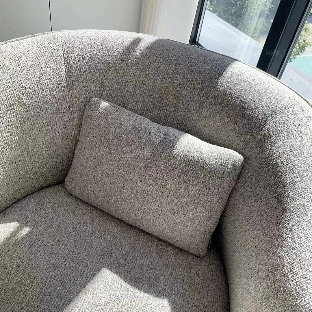 Minimalist fabric revolving 1 seater sofa heb in panoramic view.