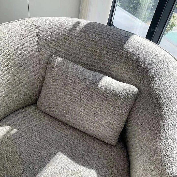 Minimalist fabric revolving 1 seater sofa heb in panoramic view.