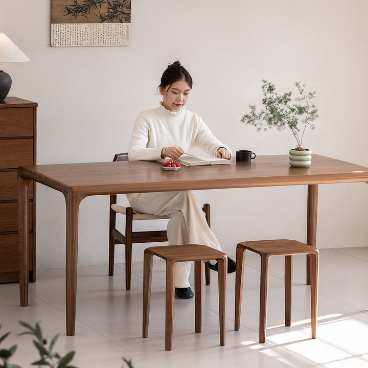 Minimalist walnut wood stool conti with context.