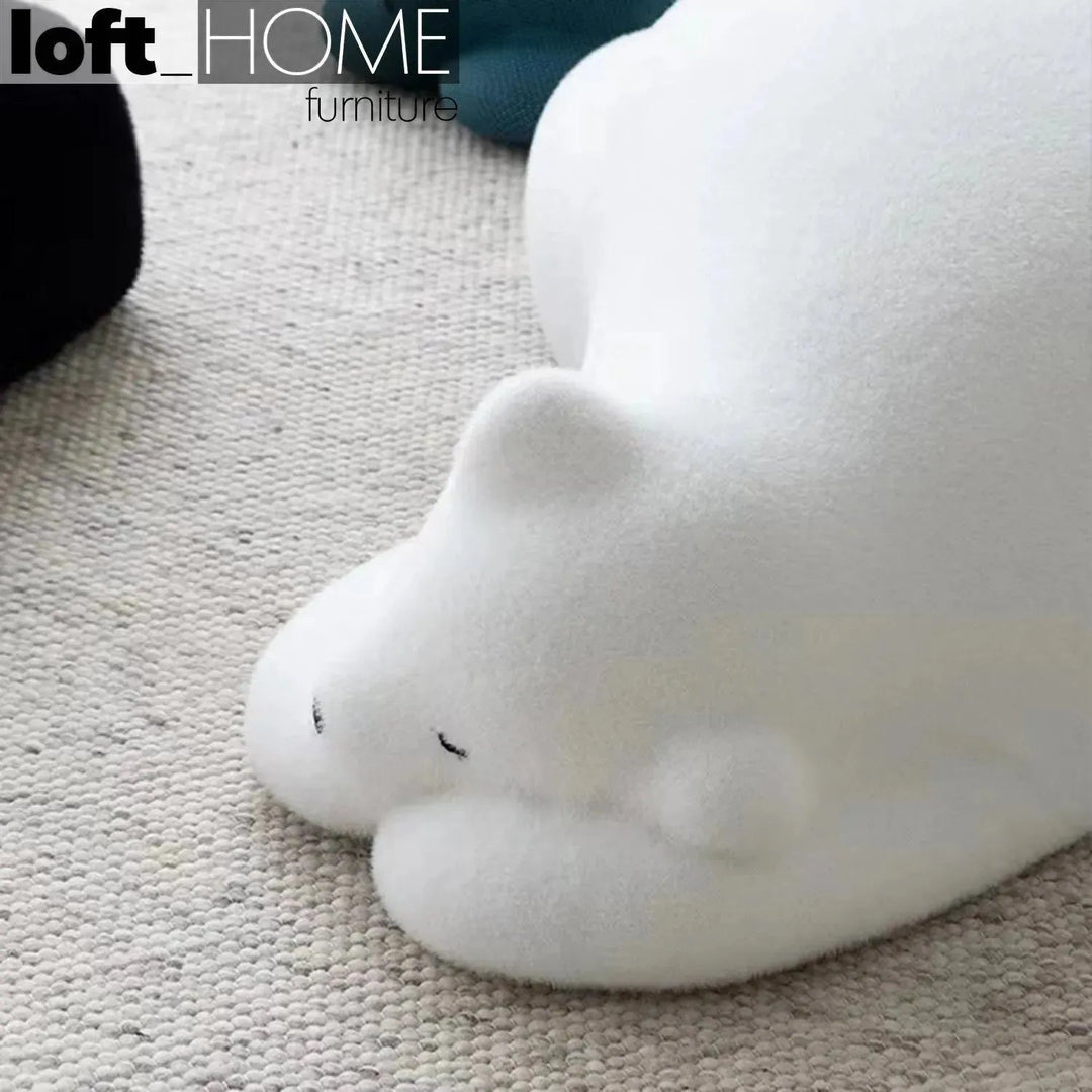 Contemporary velvet ottoman resting bear white in still life.