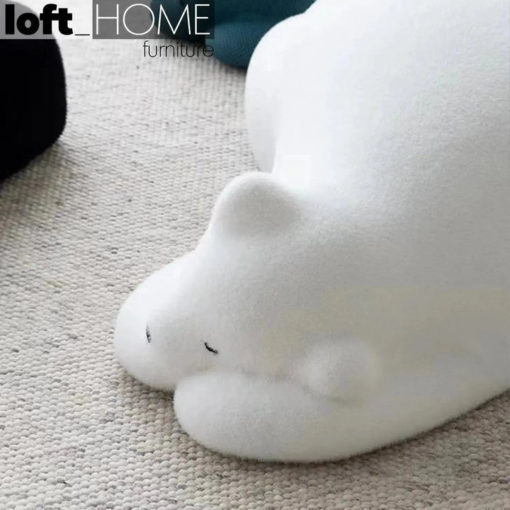 Contemporary velvet ottoman resting bear white in still life.