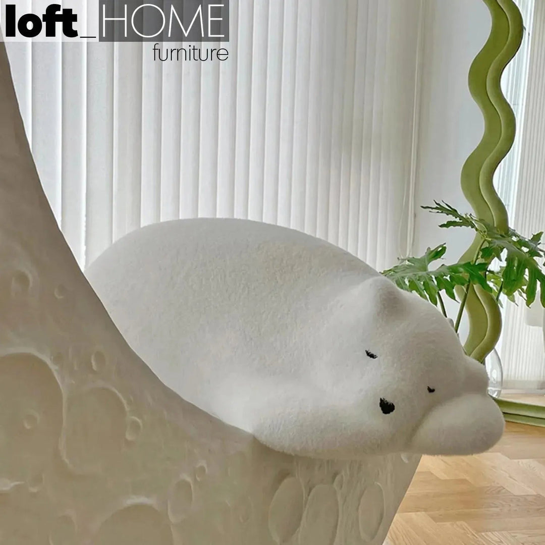 Contemporary velvet ottoman resting bear white in details.