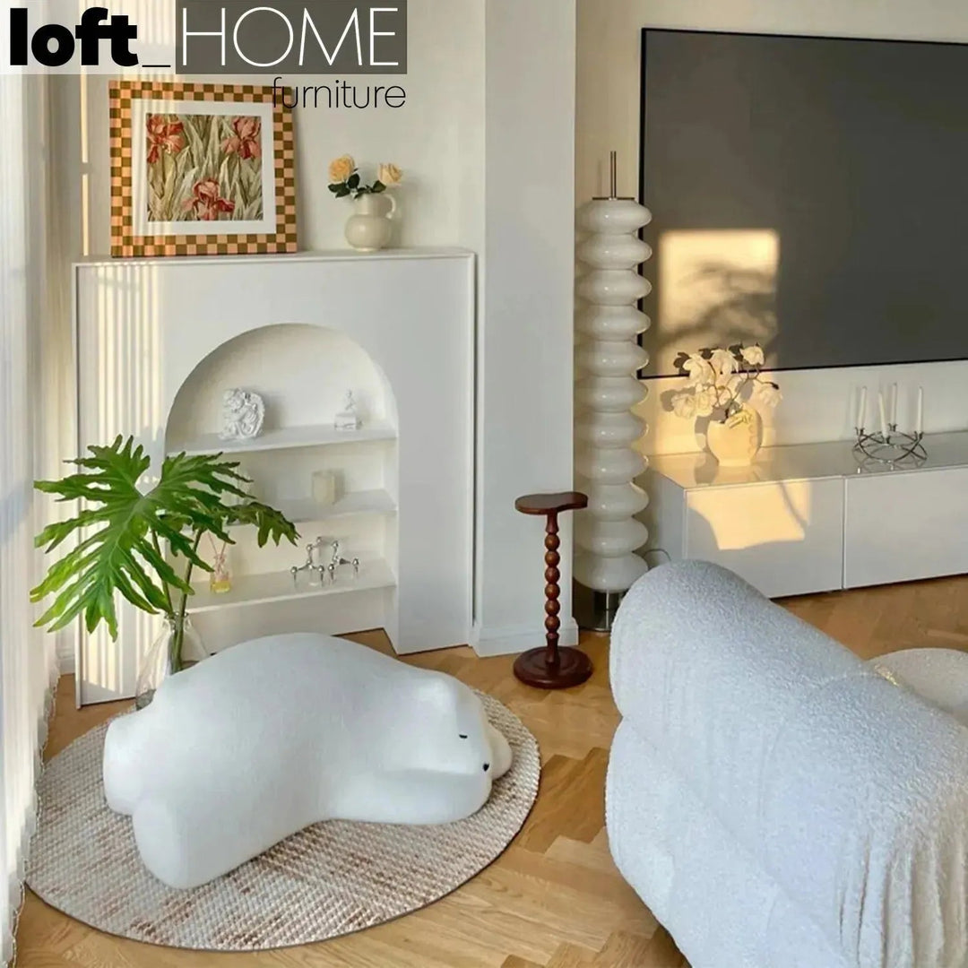 Contemporary velvet ottoman resting bear white in close up details.