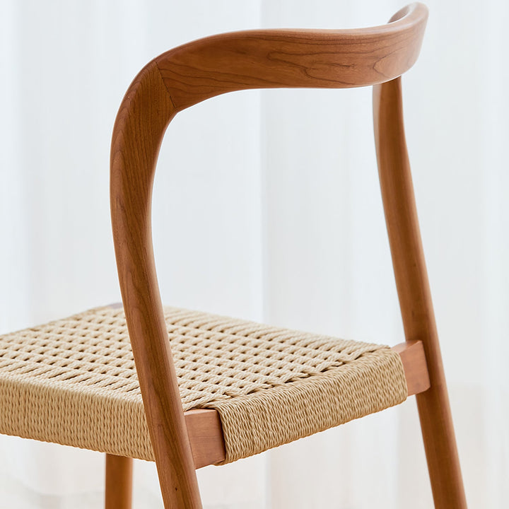 Scandinavian cherry wood woven rope dining chair sona in panoramic view.