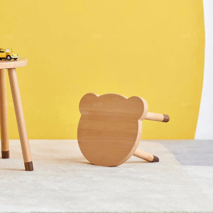 Scandinavian wood kids stool bear in close up details.