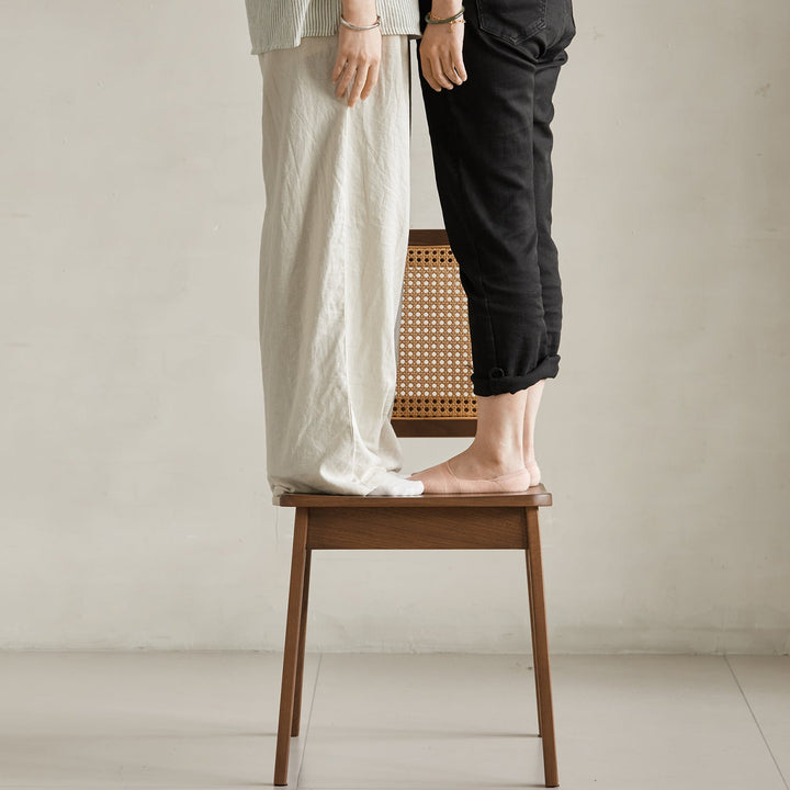 Vintage walnut wood rattan dining chair nook in panoramic view.