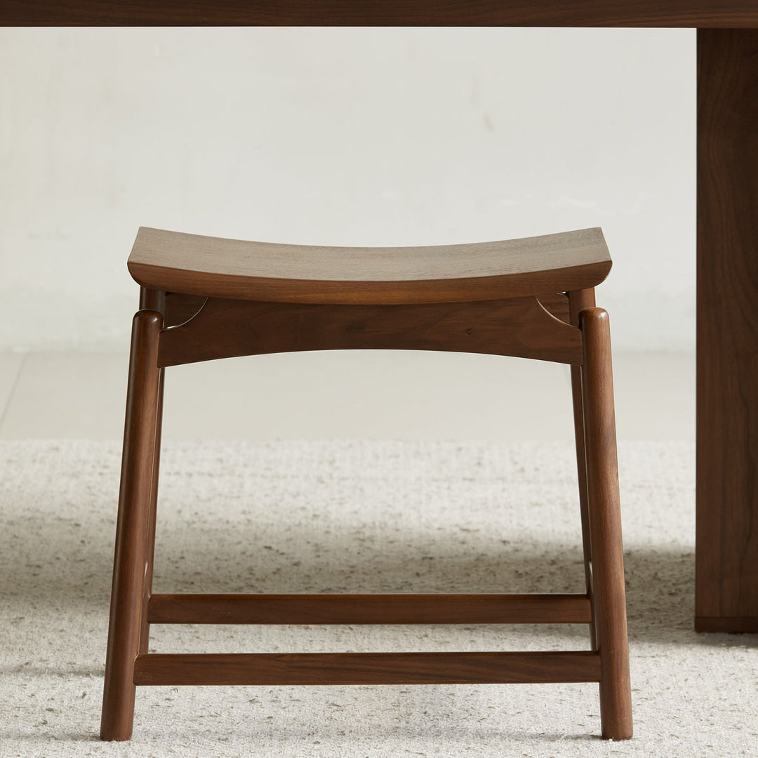 Vintage walnut wood stool arcus with context.